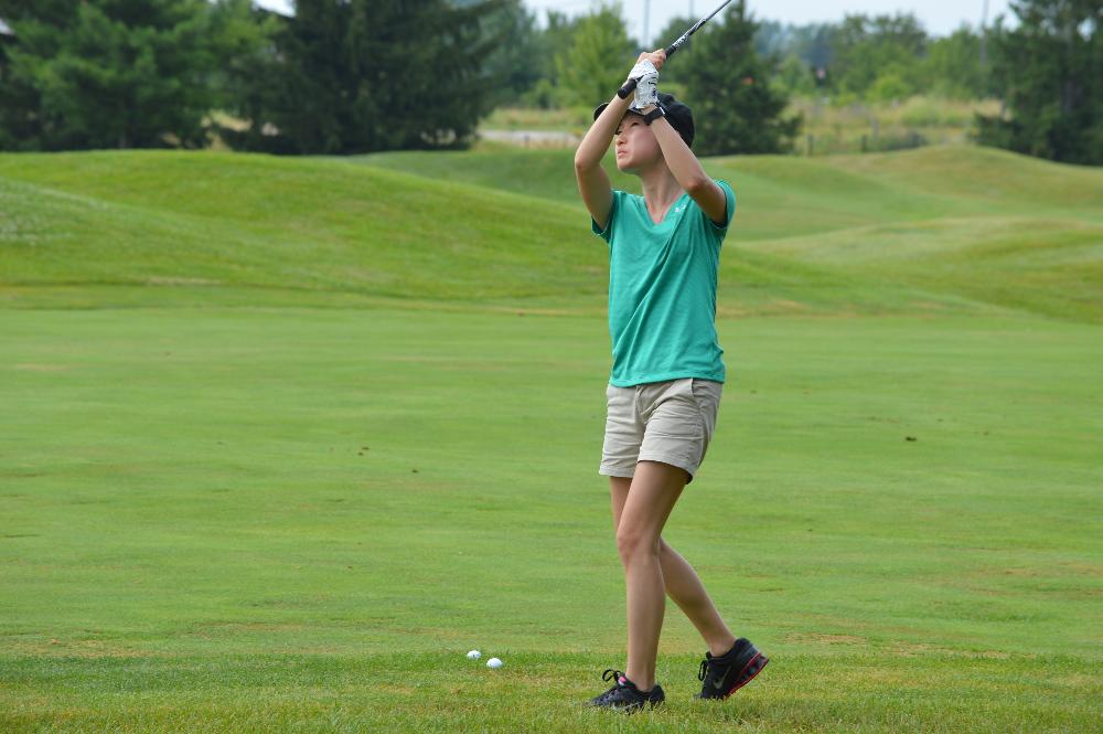 An alumna golfing at The Meadows Golf Course.